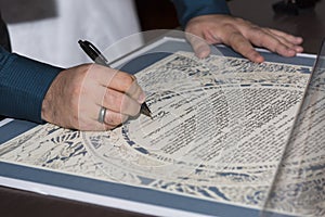 Bride and groom signing the ketubah