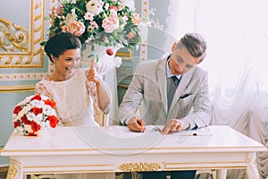 Bride and groom signing marriage license