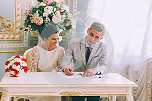 Bride and groom signing marriage license