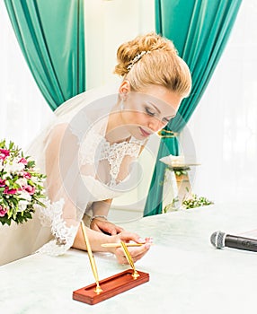Bride and groom signing marriage license or wedding contract