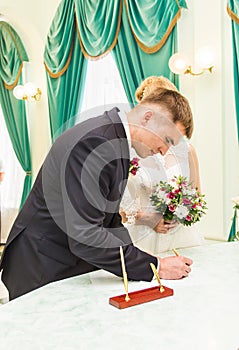 Bride and groom signing marriage license or wedding contract