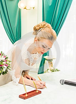 Bride and groom signing marriage license or wedding contract