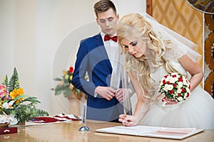 Bride and groom signing marriage wedding certificate