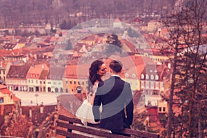 Bride and groom sitting on a bench in the city