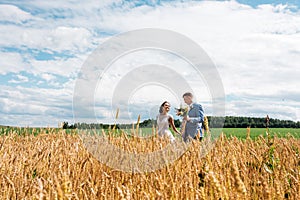 The bride and groom stand in the field