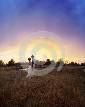 The bride and groom stand by the lake, after the wedding ceremony. Newlyweds are smiling, they are happy.