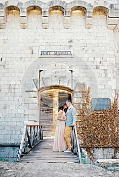 Bride and groom stand together holding hands on the bridge to Mamula Fort