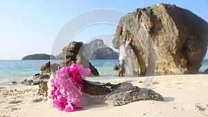 bride and groom stand in water with focus on bouquet