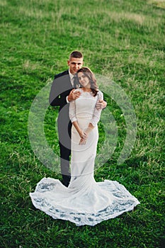 The bride and groom are standing on a hill. Embrace. wedding staging