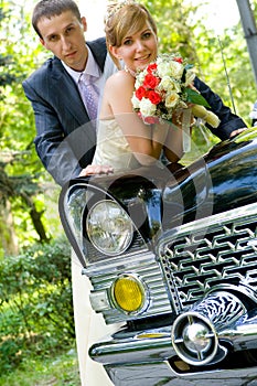 Bride and groom standing near wedding car