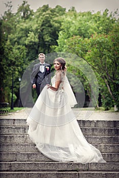 The bride and groom on the steps of the stairs. Newlyweds