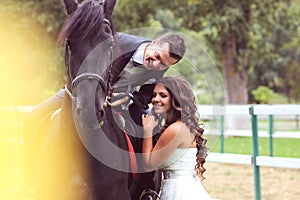 Bride and groom at stud black horse