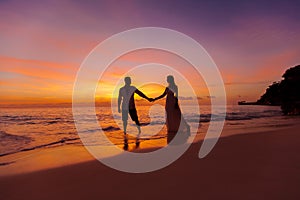bride and groom on a tropical beach with the sunset in the background