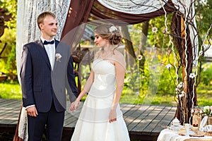 Bride and groom under decorative wedding arch