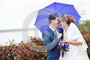 Bride and groom under umbrella