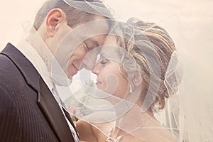 Bride and groom under veil
