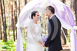 Bride and Groom Under wedding arch