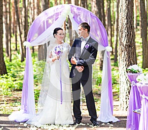 Bride and Groom Under wedding arch.