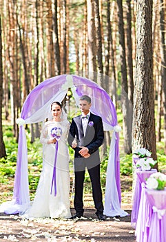 Bride and Groom Under wedding arch.