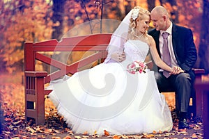 Bride and groom walking in autumn park