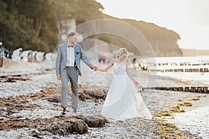 Bride and groom walking on the beach
