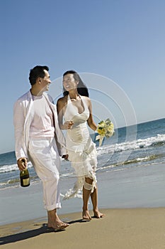 Bride And Groom walking On Beach