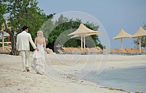 Bride and groom walking on caribbean beach