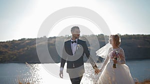 Bride and groom walking near the river