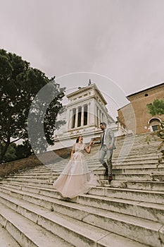 Bride and groom walking outdoors at Spagna Square and Trinita` d