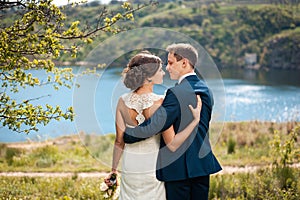 Bride and groom walking at the river