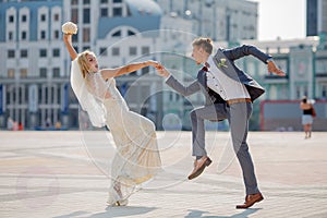 Bride and groom in wedding attire dancing fiery dance in the town