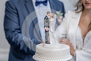 Bride and groom wedding cake topper plastic statues kissing after marriage ceremony