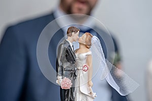 Bride and groom wedding cake topper plastic statues kissing after marriage ceremony