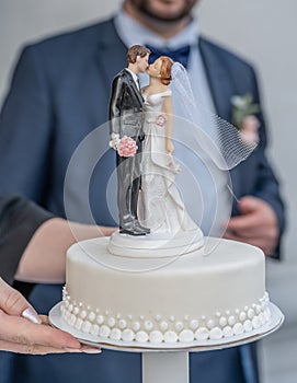 Bride and groom wedding cake topper plastic statues kissing after marriage ceremony