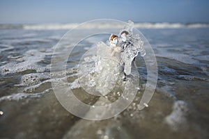 Bride and Groom Wedding Cake Topper Wearing Surgical Masks in the Waves of the Ocean