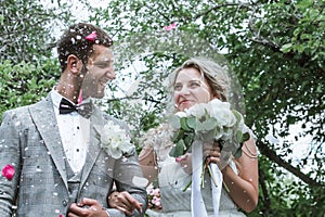 Bride and groom at the wedding ceremony. congratulations of the guests. showering with rose petals. selective focus.