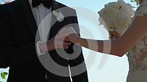 Bride and groom at wedding ceremony. Man put on a ring on a woman finger.