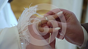 Bride and groom at wedding ceremony. Man put on a ring on a woman finger.
