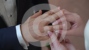 Bride and groom at wedding ceremony. Man put on a ring on a woman finger.