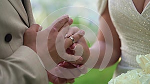 Bride and groom at wedding ceremony. Man put on a ring on a woman finger.