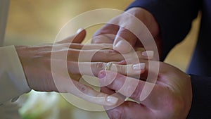 Bride and groom at wedding ceremony. Man put on a ring on a woman finger.