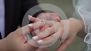 Bride and groom at wedding ceremony. Man put on a ring on a woman finger.