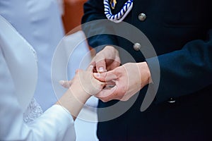 the bride and groom during the wedding ceremony put wedding rings on their fingers