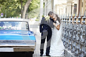 The bride and groom on the wedding day to the car.