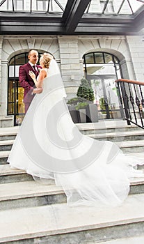 Bride and groom at wedding Day walking Outdoors. Happy Newlyweds embracing. Loving couple.