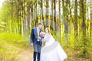 Bride and Groom at wedding Day walking Outdoors on spring nature. Bridal couple, Happy Newlywed woman and man embracing
