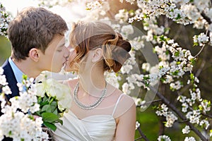 Bride and groom at the wedding kiss in spring walk Park