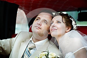 The bride and groom in a wedding limousine