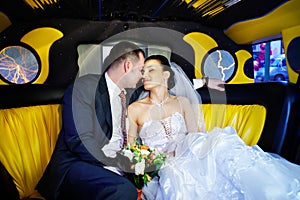 The bride and groom in a wedding limousine