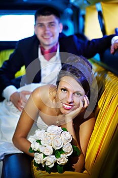 Bride and groom in wedding limousine